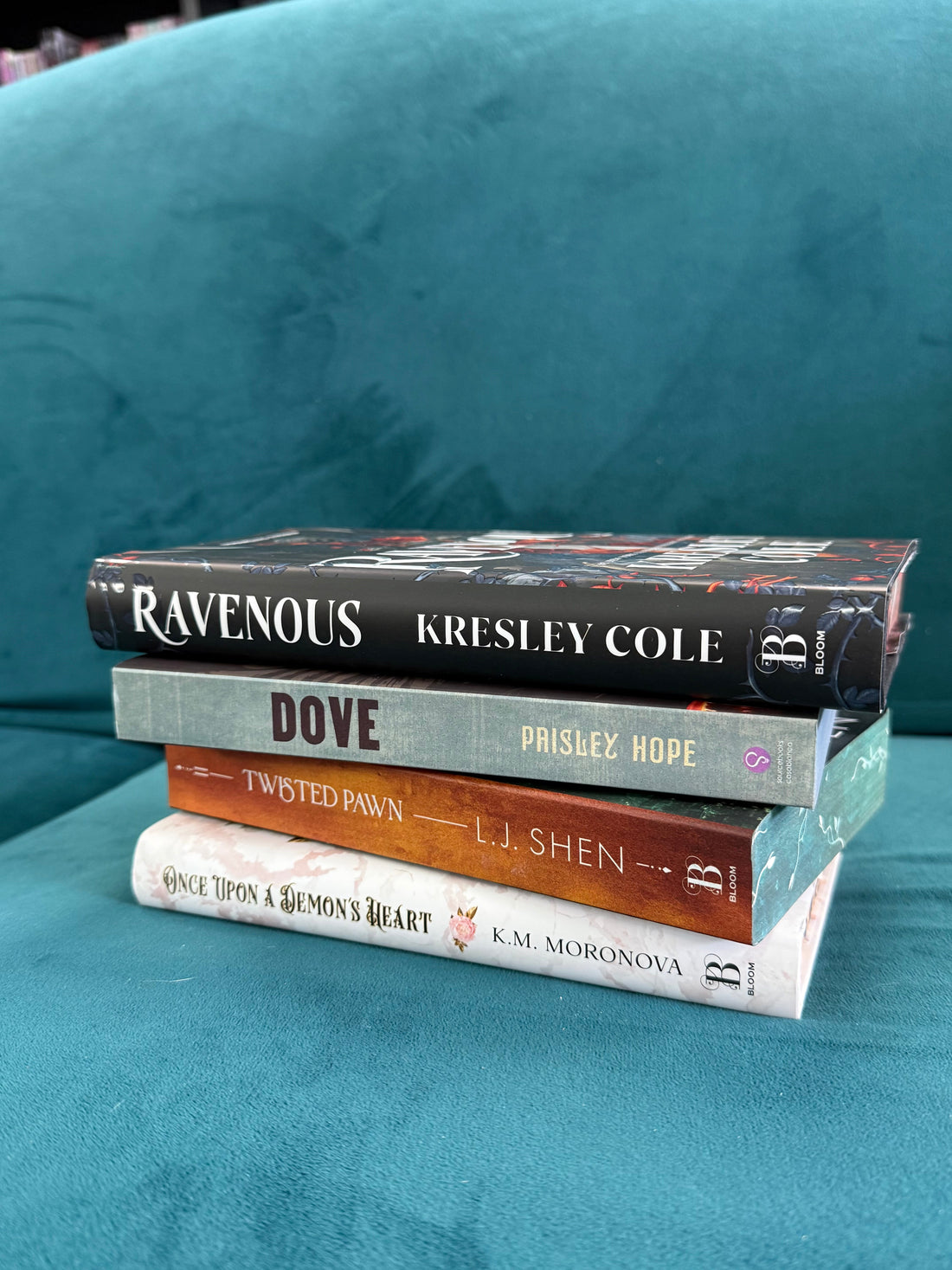 Dark romance book stack featuring Twisted Pawn, Fallen Rook, King of Gluttony, Ravenous, Once Upon a Demon’s Heart, Dove, Foxx, and Fury Bound.